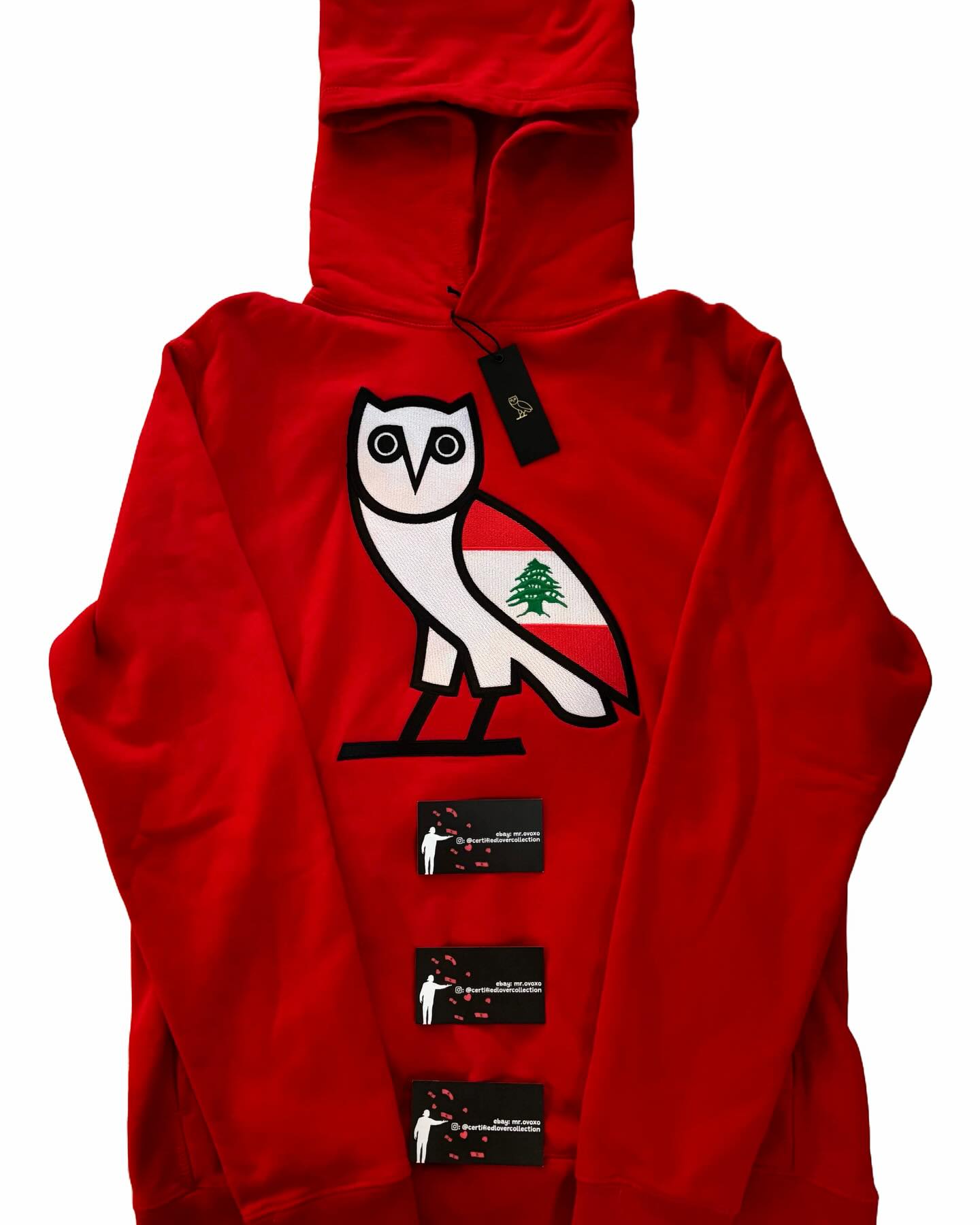 Red hoodie with an owl design and visible branding on a white background