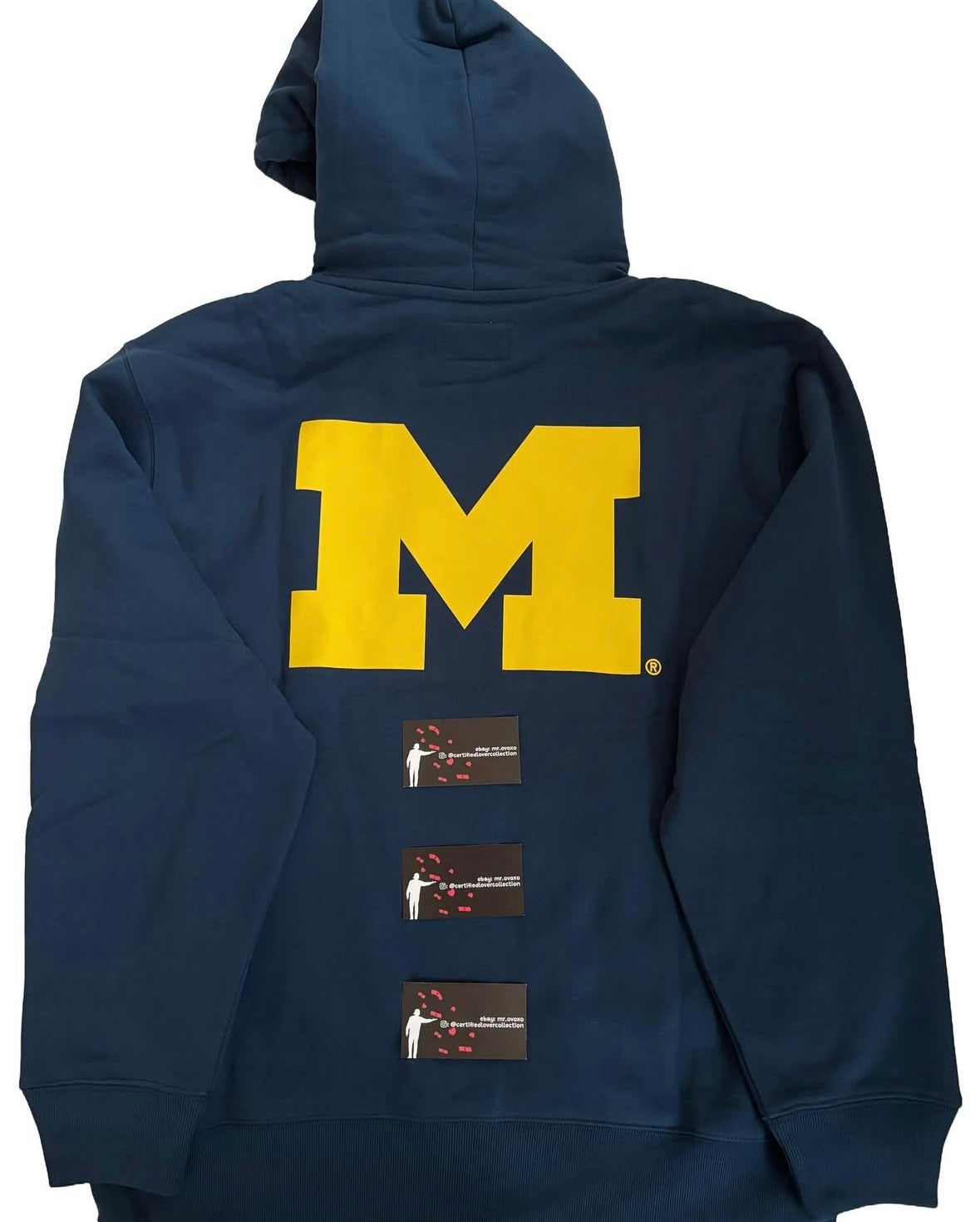 Navy hoodie with a large yellow 'M' on the back, displayed against a white background.