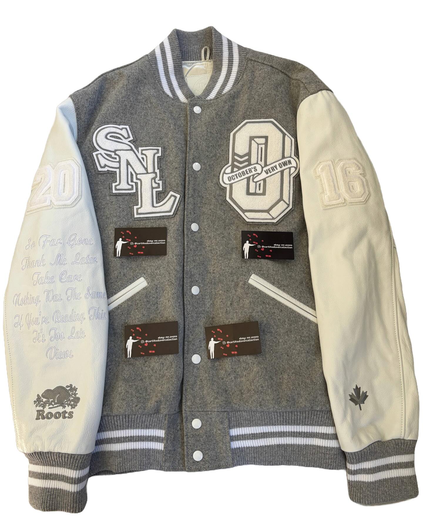 Gray and white varsity jacket with various patches and logos on a white background