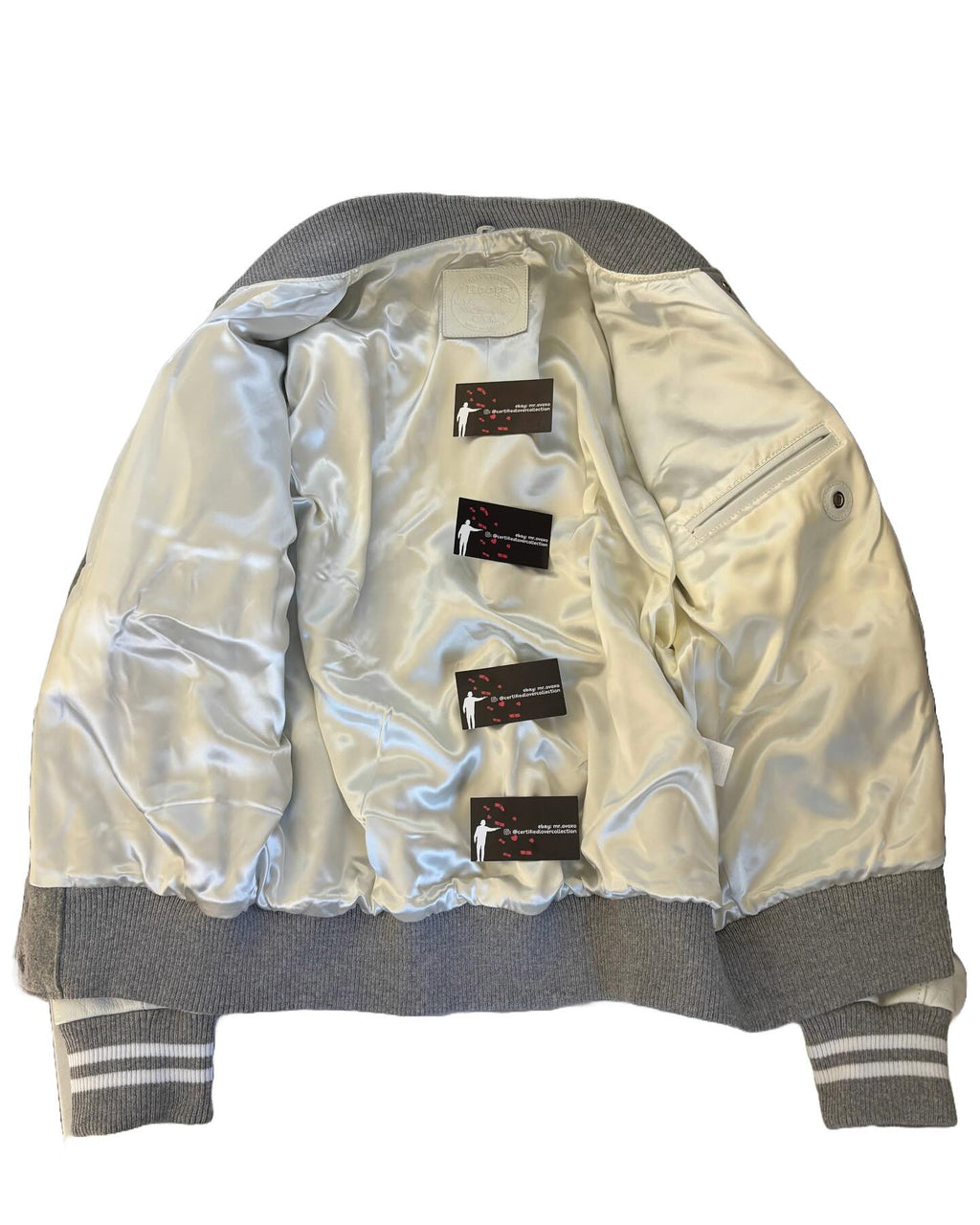 Silver jacket with multiple labels on a white background