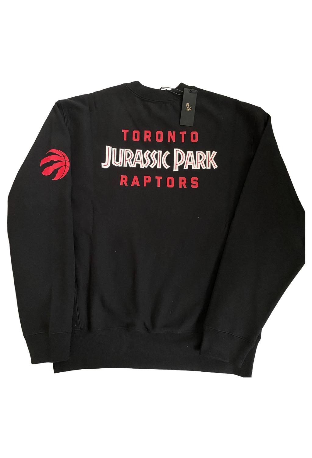 Black sweatshirt with 'Toronto Jurassic Park Raptors' text and logo on a white background. OVO X Toronto Raptors X Jurassic Park X Dino Shattered Backboard Crewneck