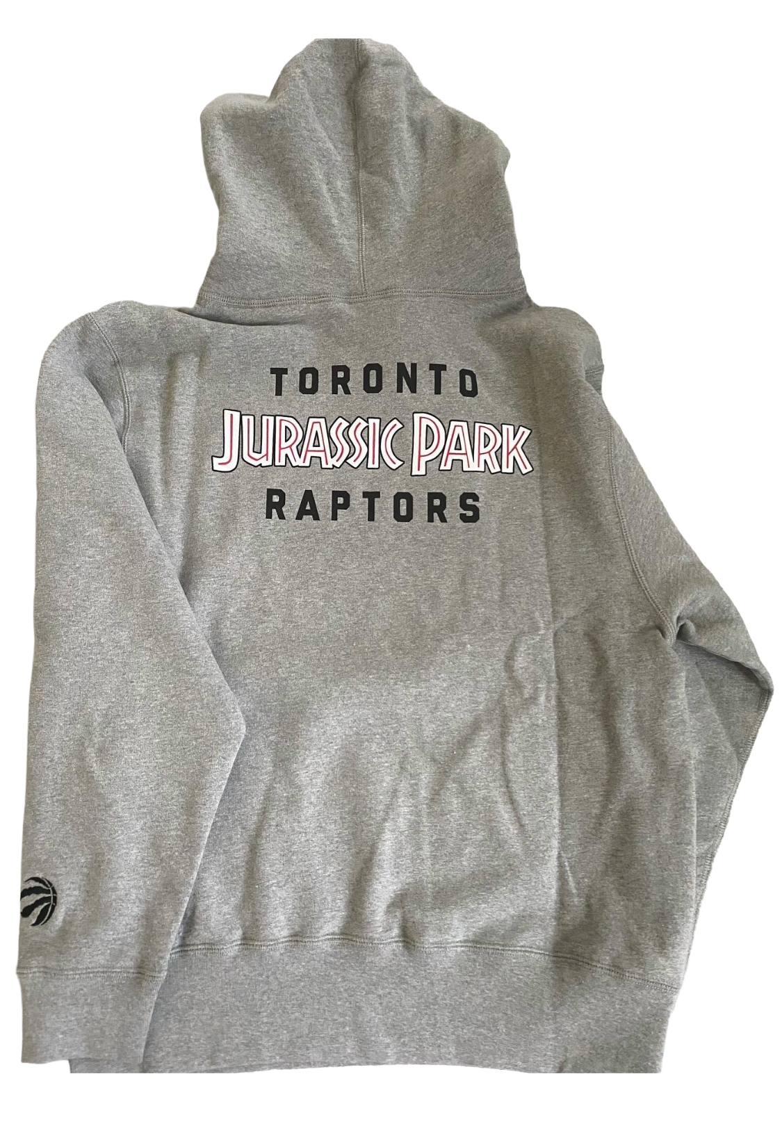 Gray hoodie with 'Toronto Jurassic Park Raptors' text on the back, displayed flat. OVO x Jurassic Park x Raptors OG Owl Hoodie 2021