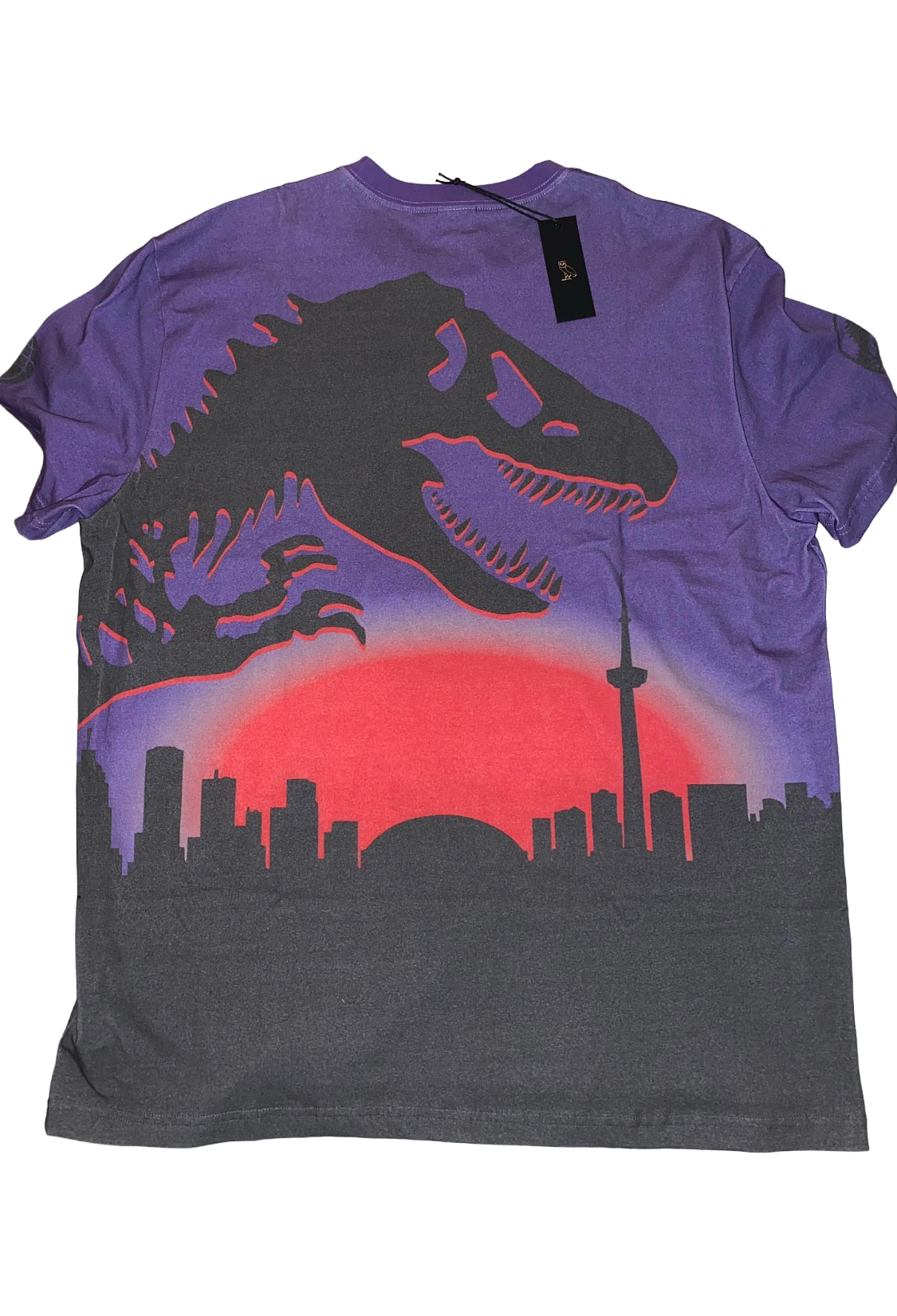 Purple t-shirt with dinosaur and cityscape design on a white background OVO x Jurassic Park x Raptors Skyline Tee 2021