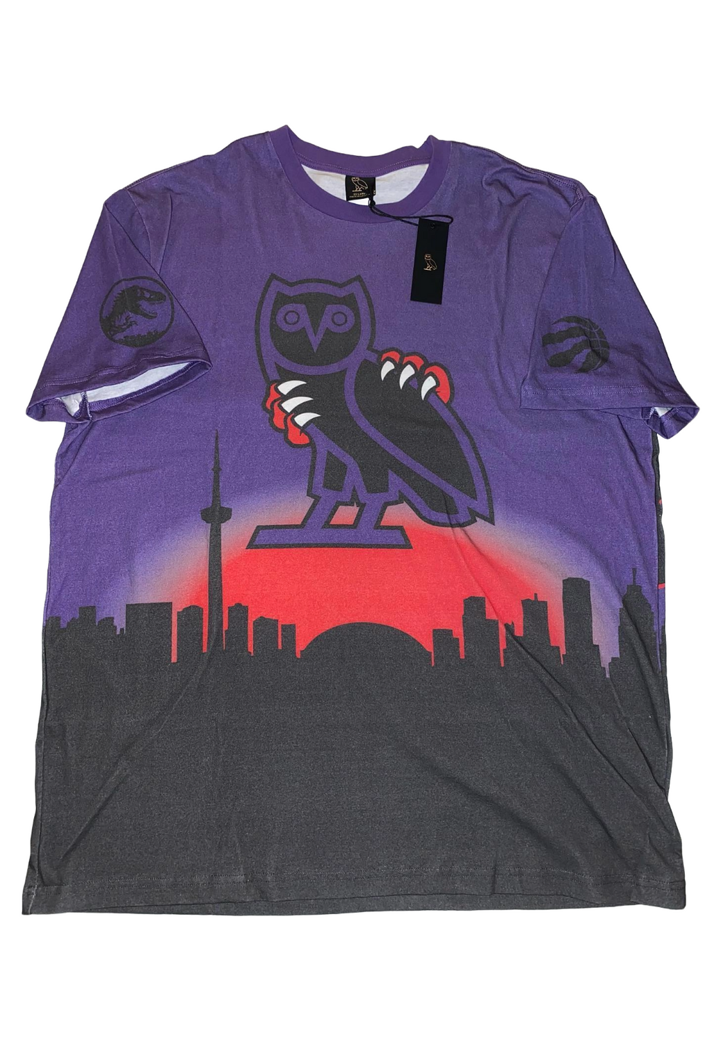 Purple t-shirt with owl graphic and cityscape design on a white background OVO x Jurassic Park x Raptors Skyline Tee 2021