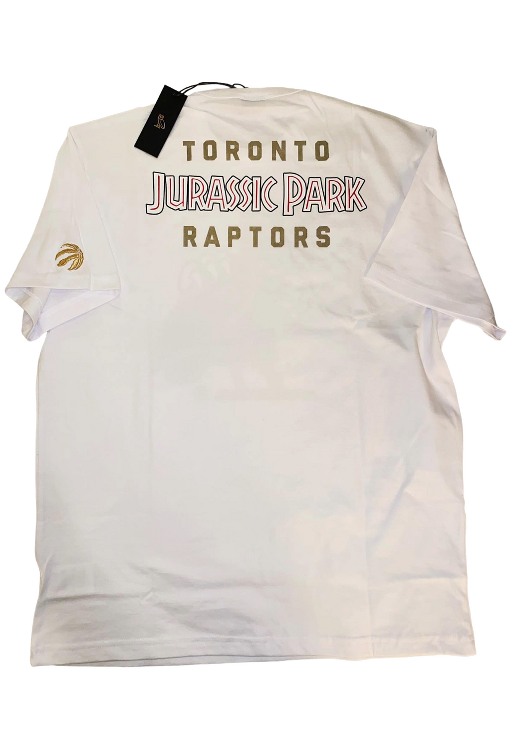 White t-shirt with 'Toronto Jurassic Park Raptors' text on a white background. OVO x Jurassic Park x Raptors